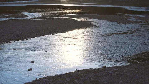 Partially iced river flowing into a mountain lake Stock Footage 71378069