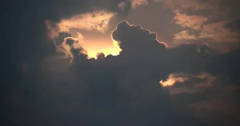 Partially obscured sunset filters through billowing cumulonimbus time lapse Stock Footage 152528545