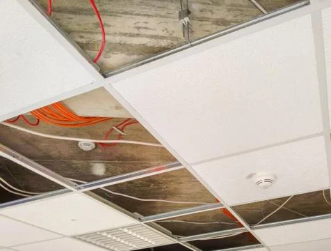 Partially open suspended ceiling with plenum area visible above panels Stock Photos