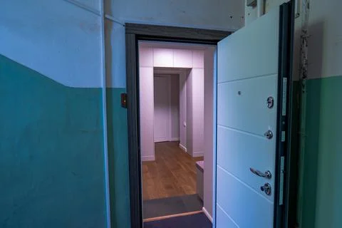Partially Open White Security Door to Modern Apartment Hallway Stock Photos