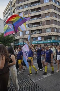 Participant holding rainbow flag while walking in pride parade procession Stock Photos