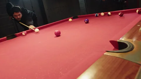 Participant prepares and executes powerful shot on billiards red game table Video stock 329193015