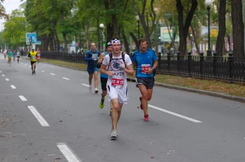 Participant using hydration pack running marathon race Foto stock