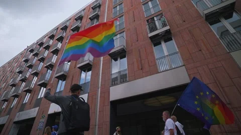 Participant is waving rainbow flag high an LGBT pride. Berlin, 22 Juli 2023. Stock Footage 313610171