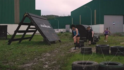 Participants in an obstacle course dragging wheels Stock Footage 137945001