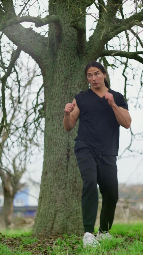 Participating in Engaging and Dynamic Martial Arts Stunts Near a Beautiful, Lush Stock Footage 305322964