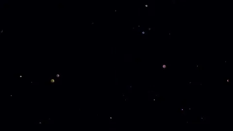 Particles randomly move among the bokeh on a black background. Abstract decorati Video stock 138129547