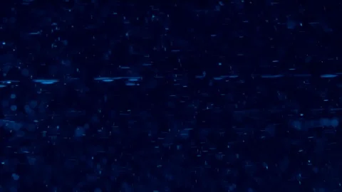 Particles swirling with bubbles in clear liquid under blue light Stock Footage 114085849