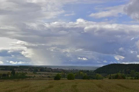 Partly cloudy. The bright sun and heavy ragged clouds in the sky. Autumn in t Stock Photos