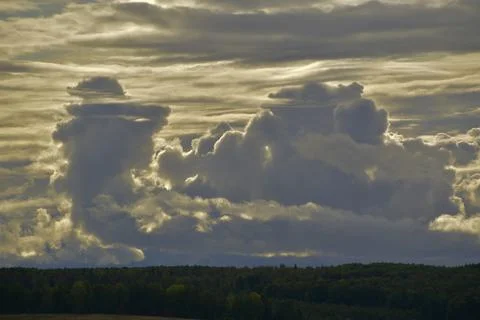 Partly cloudy. The bright sun and heavy ragged clouds in the sky. Autumn in t Stock Photos