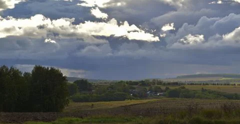 Partly cloudy. The bright sun and heavy ragged clouds in the sky. Autumn in t Stock Photos