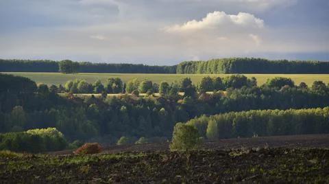 Partly cloudy. The bright sun and heavy ragged clouds in the sky. Autumn in t Stock Photos