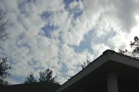 Partly Cloudy turns to Storm Clouds move in behind house roof Stock Footage 10757465