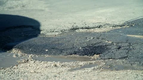 Partly fixed hole in road while car drives over Stock Footage 27846131