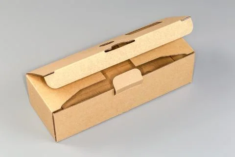 Partly open rectangular cardboard packing box on a gray background Stock Photos