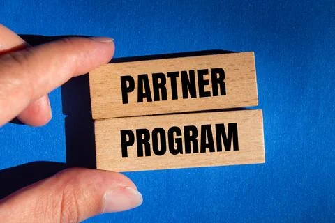 Partner program message written on wooden blocks on blue background. Conceptu 스톡 사진