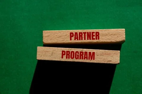 Partner program message written on wooden blocks on green background. Concept Foto stock