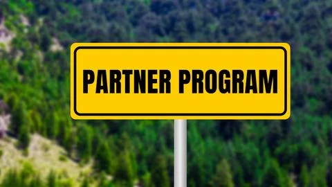 Partner program message written on yellow metal sign  on nature background. C Stock Photos