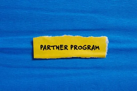 Partner program words written on ripped yellow paper with blue background Foto stock