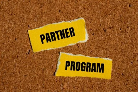 Partner program words written on ripped yellow paper with brown background 写真素材