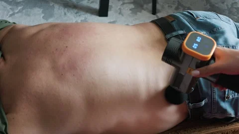 Partner Using Percussion Massager on Man Lower Back for Muscle Pain Видео 335230849