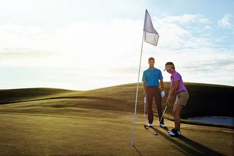 Partners on and off the fairway. a couple playing golf together on a fairway. Stock Photos