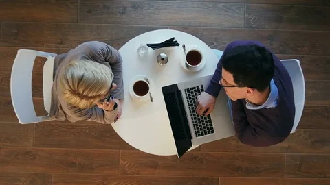 Partners enjoying work in bright modern cafe, woman having a phone call, man Stock Footage 78730237