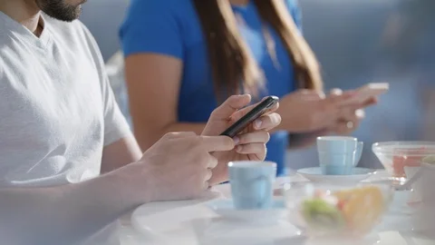 Partners Using Phone While Eating Breakfast Together Stock Footage 91740766