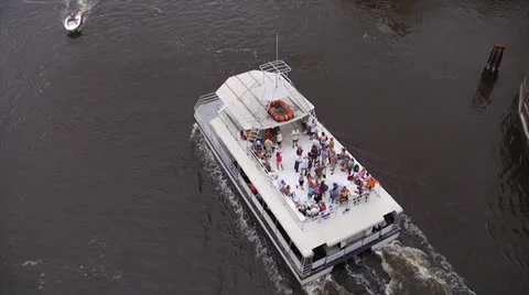 Party barge glides from under bridge on waterway, ship passes b, 60fps Stock Footage 24411822
