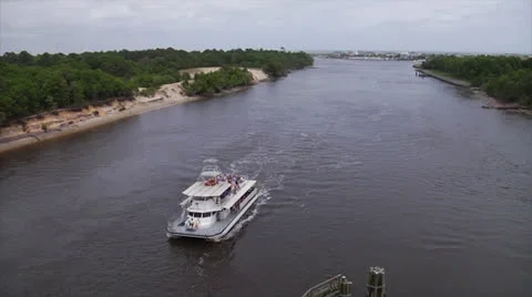Party barge glides under bridge on waterway a, 60fps Stock Footage 24414946
