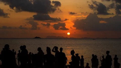 A party on the beach at sunset. Unrecognizable people admire the sunset at sea Stock Footage 123388762