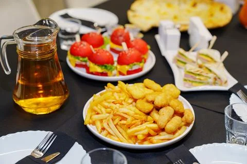 Party buffet table with plate of crispy french fries and chicken nuggets Stock Photos
