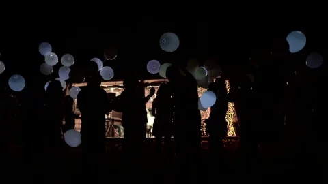 The party came to an end. A group of people lets out balloons back to the sky Stock Footage