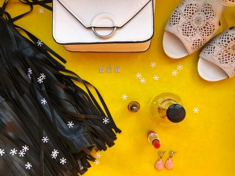 Party style flat lay. Female fashion. Black leather skirt with fringe, white  Stock Photos