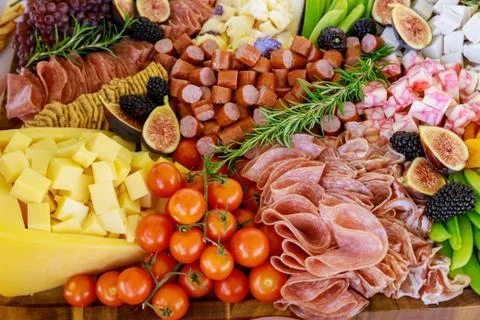 Party table with cut fruit, ham and cheese. Stock Photos