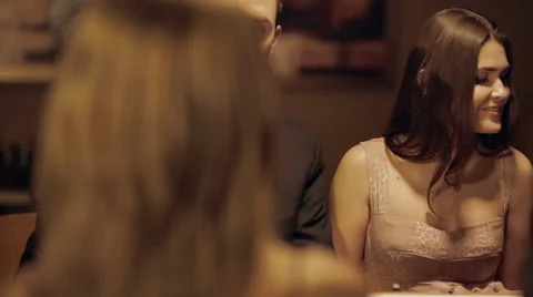 Partygoers converse as player makes his move Stock Footage 42893989