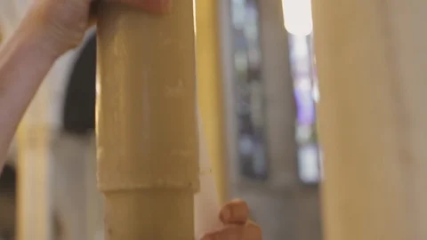 Pascal candle. Man taking light from the candle during baptism. Stock Footage 88575460