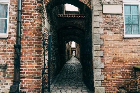 Passage arch corridor between streets inside brick residential building Stock Photos