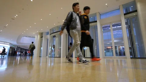 Passage at modern shopping complex, two guys pass by, glass doors of elevators Stock Footage 97962208