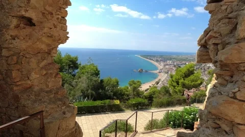 Passage through a hole in the wall and view of the bay of Castillo de Juan - Stock Footage 249755872