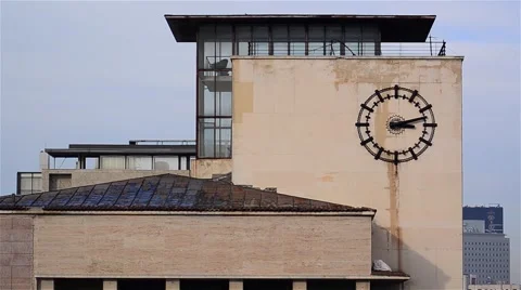 Passage of time marked by metal clock mounted on the wall of a building in do Stock Footage 62060231