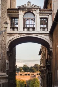 Passage under an old bridge between two buildings in Rome Stock Photos