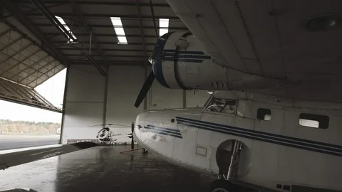 Passanger  Propeller plane stopped in a hangar Stock Footage 127427306