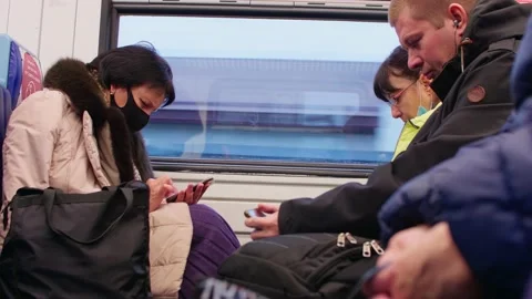 Passangers are sitting in wagon of train. They are using smartphones and Stock Footage 147724112