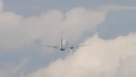 Passenger airplane climbing into cloudy sky after takeoff Stock Footage 338030598