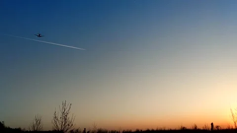 Passenger airplane flies at sunset Stock Footage 244333360