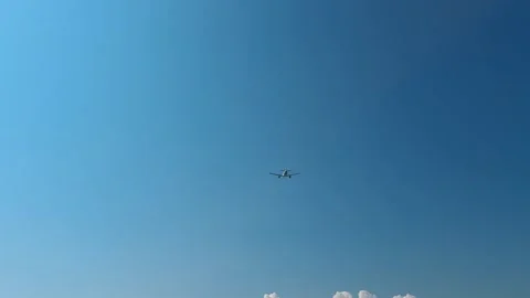Passenger airplane flies through a clear blue sky over Montenegro with landing Stock Footage 344903682