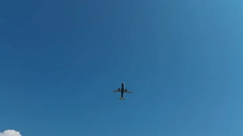 Passenger airplane flies through a clear blue sky over Montenegro with landing Stock Footage 344903713