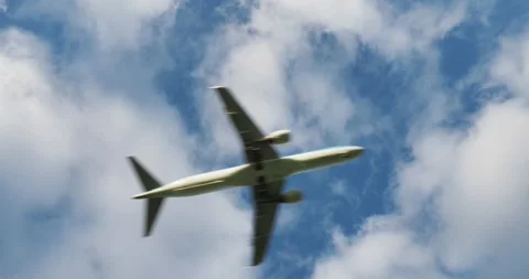 Passenger airplane flying overhead through clouds Stock Footage 300617536