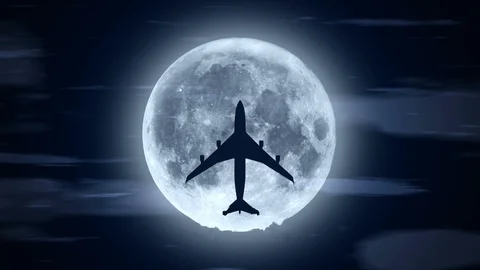 Passenger airplane over moon in cloudy night Stock Footage 107982055